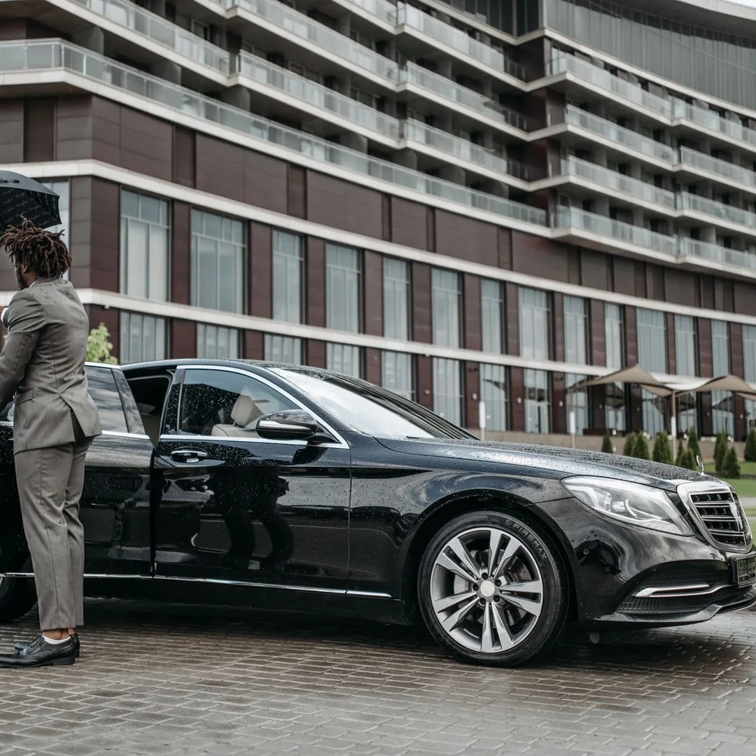 Professional chauffeur with luxury black car